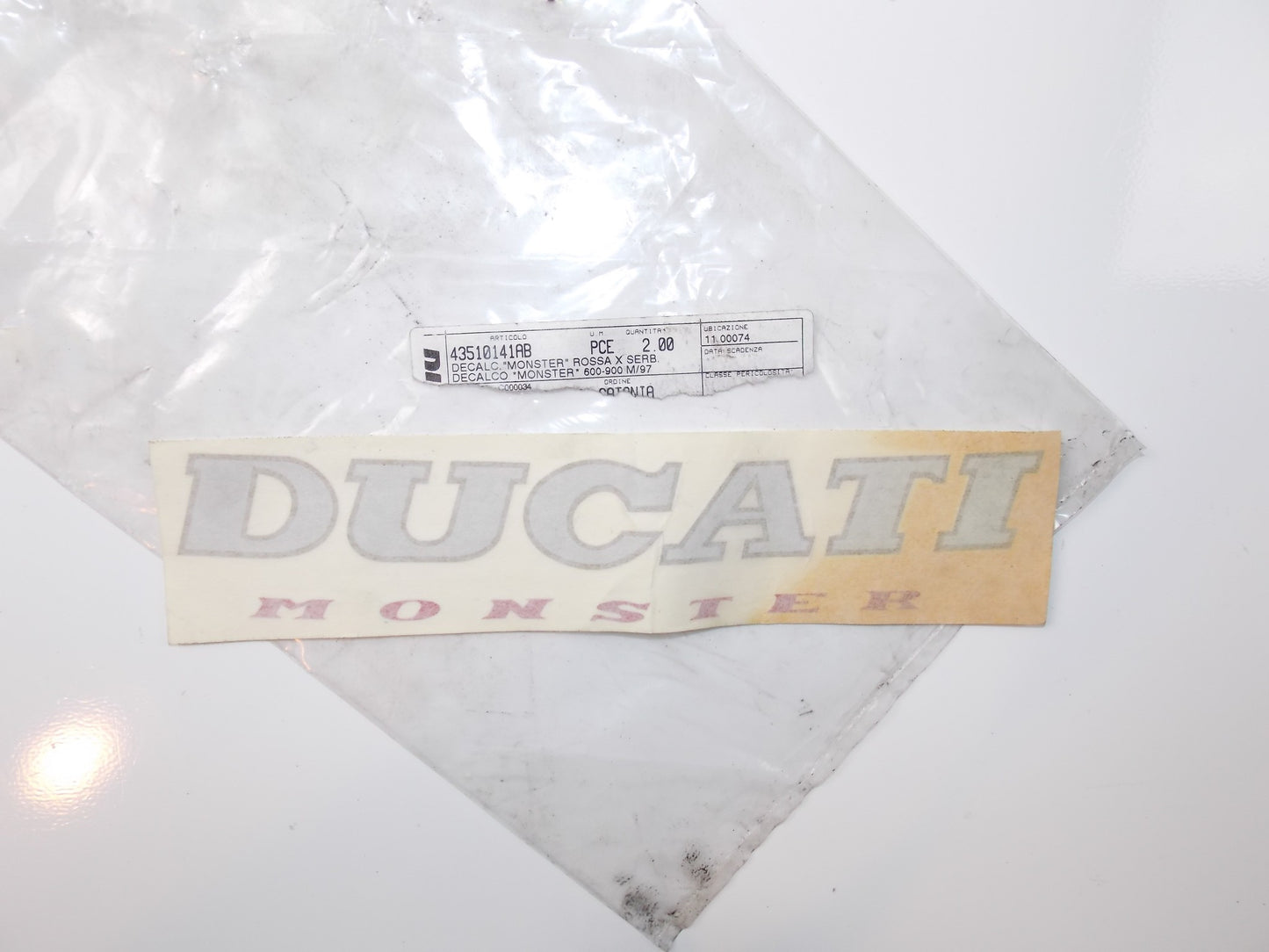 NOS OEM DUCATI 97 600/900 M "DUCATI MONSTER" 8 7/8" x 2 1/8" STICKER 43510141AB - MotoRaider